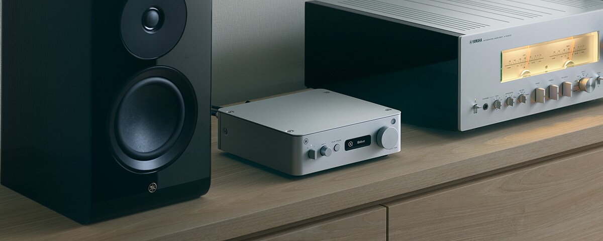 Yamaha WXC-70A lecteur réseau Hi-Fi argent entre une enceinte colonne et un ampli intégré Yamaha